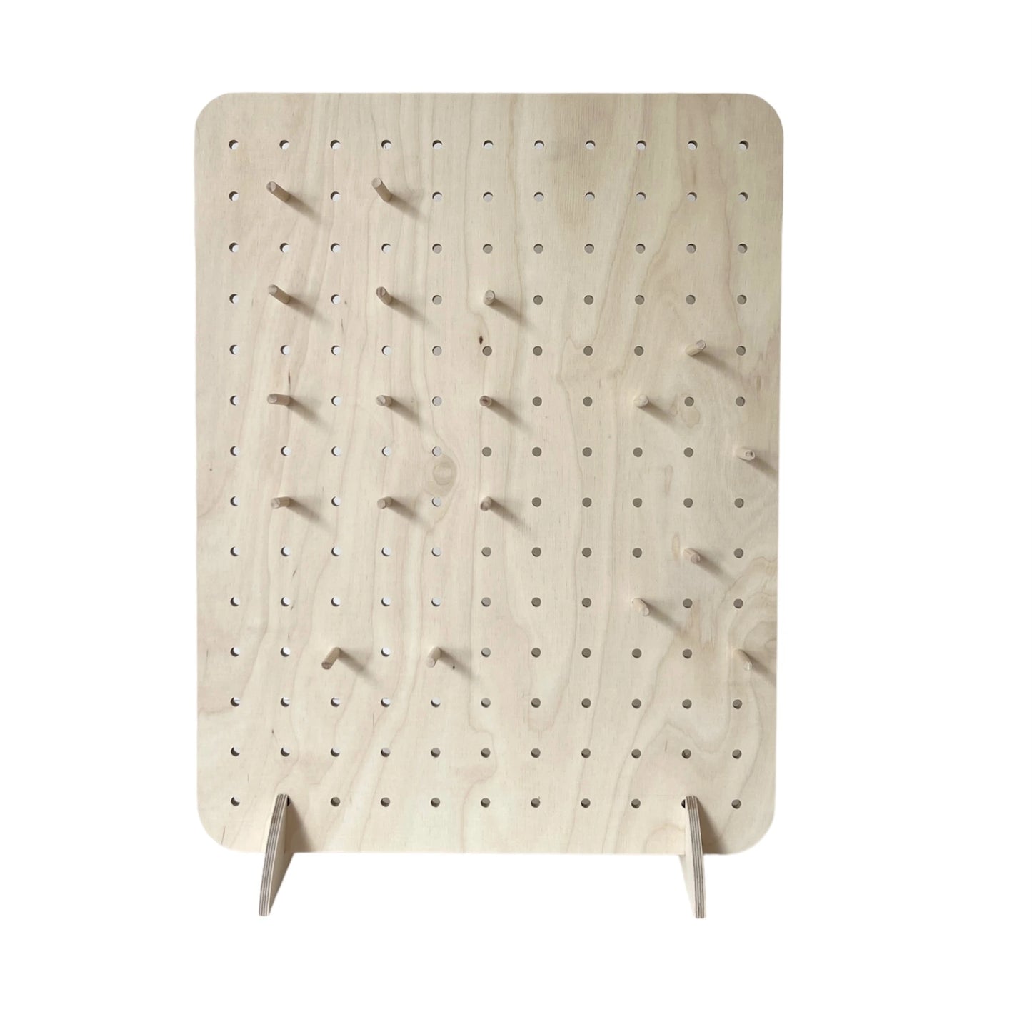 Pale wooden pegboard with small 6mm drilled holes and some pegs facing to front.