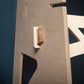 details of wooden wedges used to construct a plywood stand up/sit down desk against a dark blue wall.