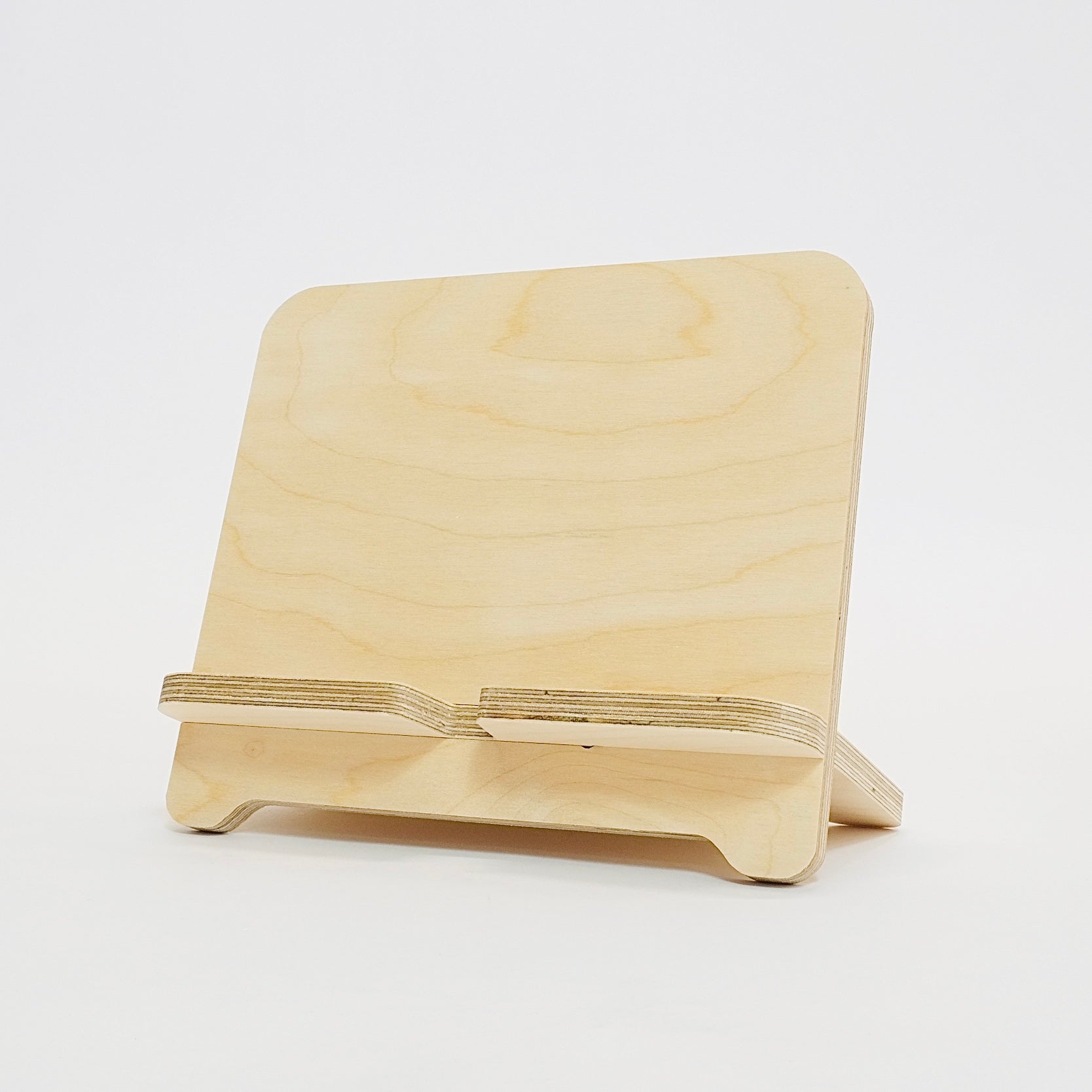 A birch plywood tablet stand, angled to the left.