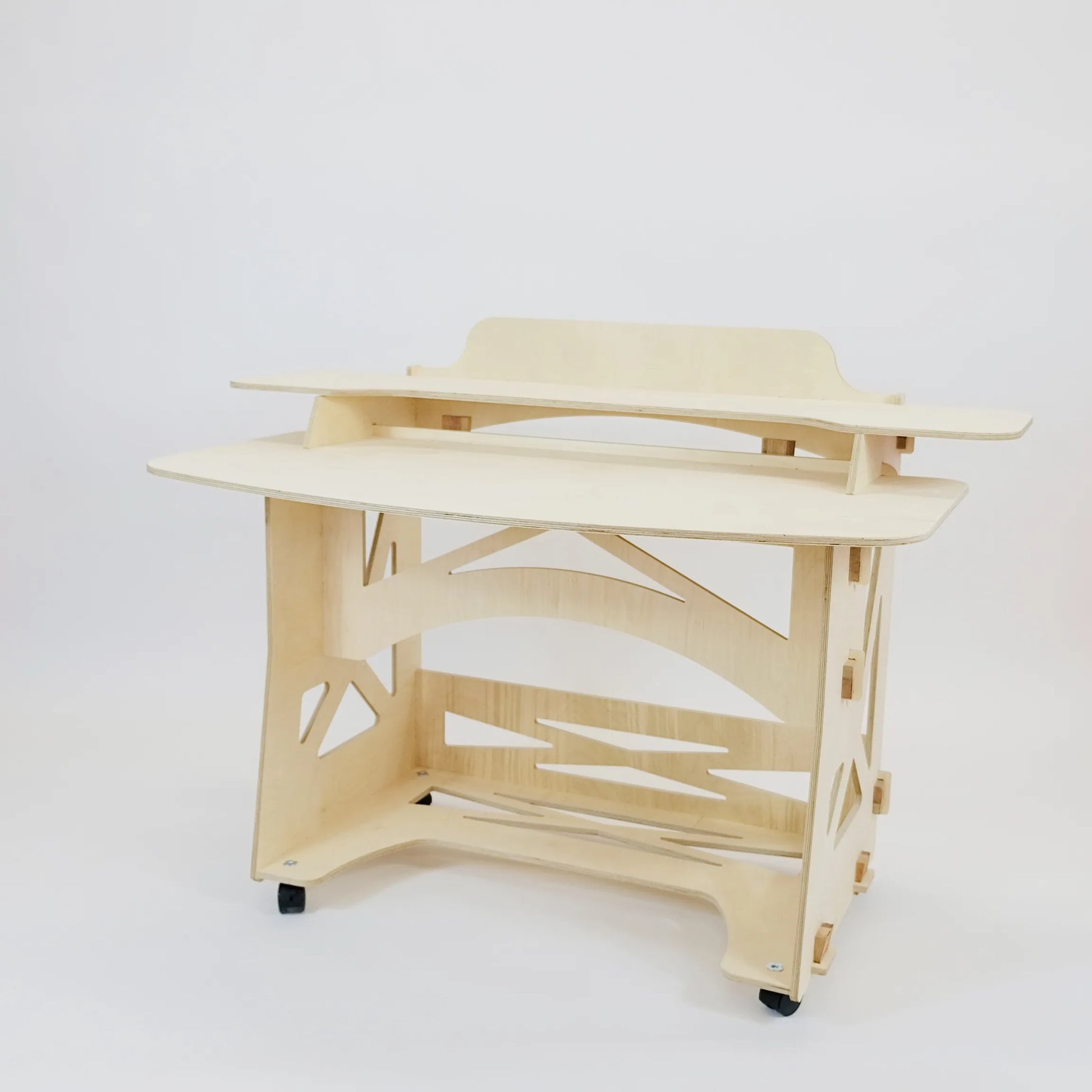 A pale wooden desk sits facing diagonally to the left. There are castors and two desk top levels. 