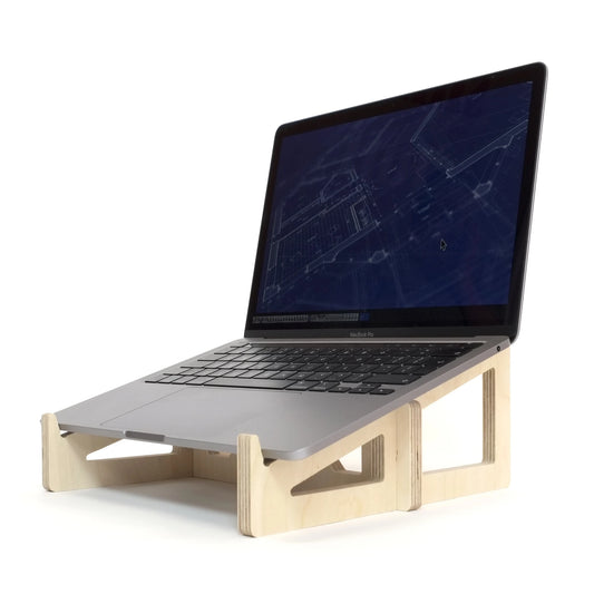 Wooden slot together laptop stand sits facing diagonally left, with open computer on showing blueprint images.