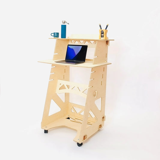 Pale birch plywood stand up/sit down desk with desktop set to standing position, on which sits a laptop, pen pot & water bottle on a white background.