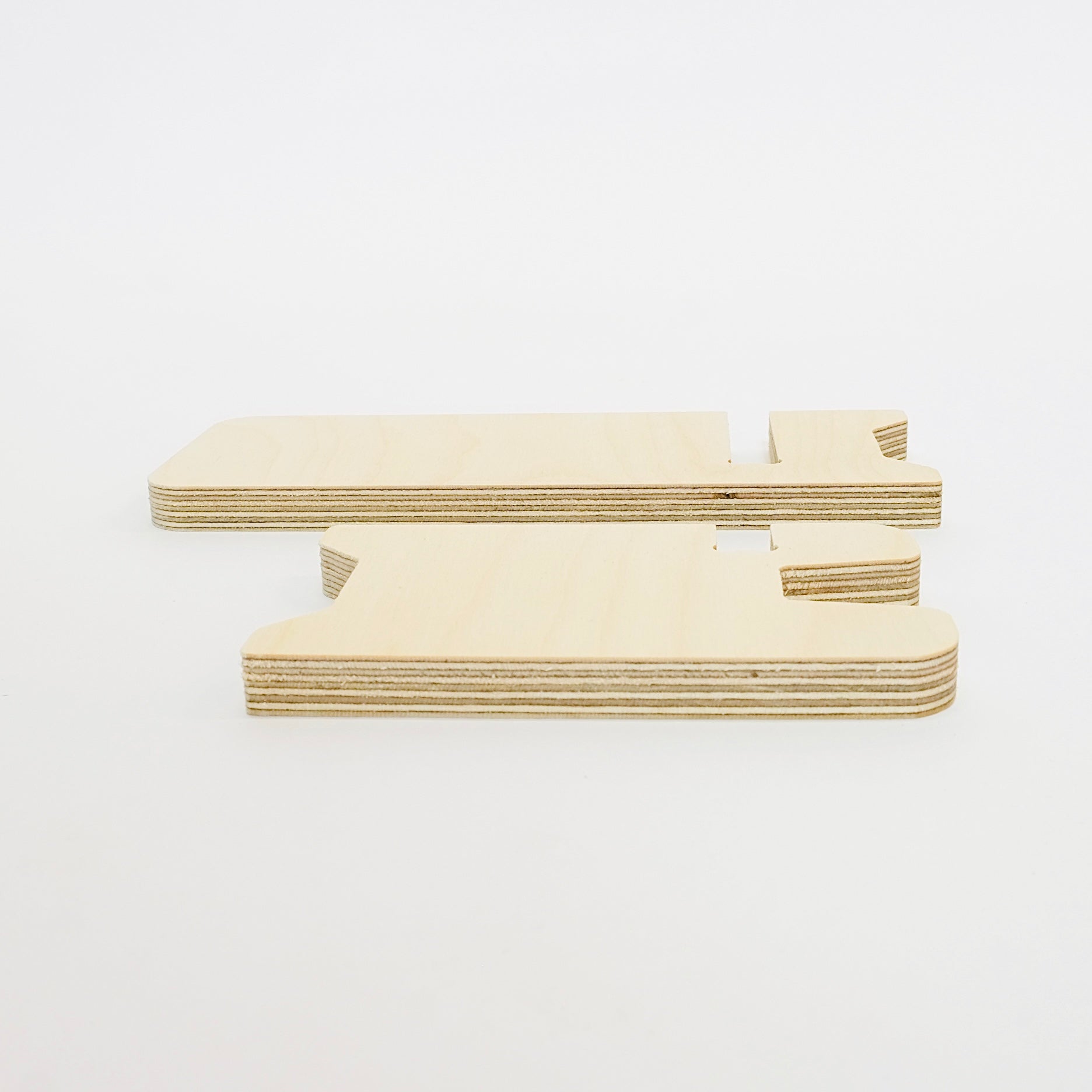 plan view of two pieces of a pale wood birch plywood phone stand lying side by side.